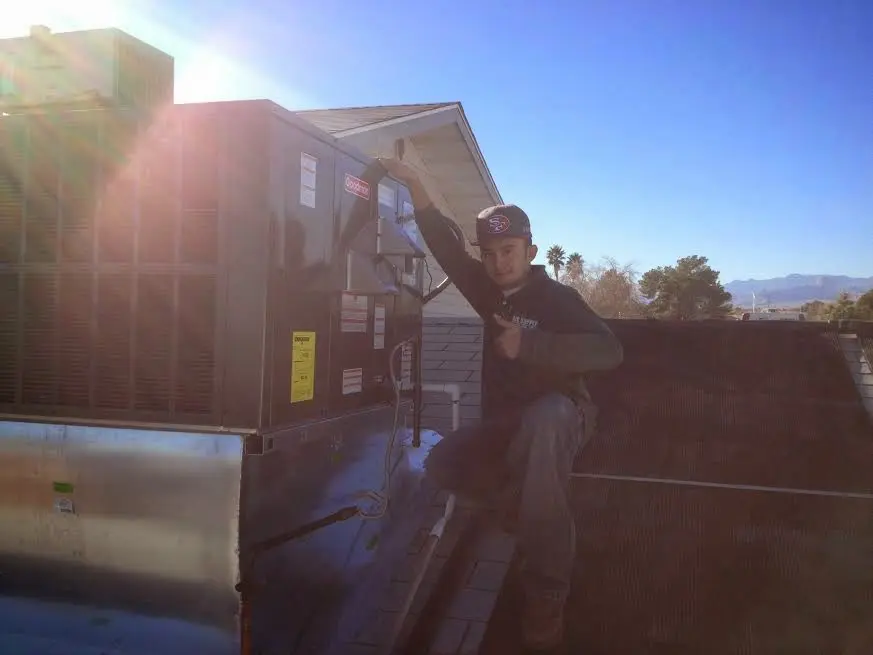 HVAC technician performing HVAC Inspection on a rooftop unit in Farmington